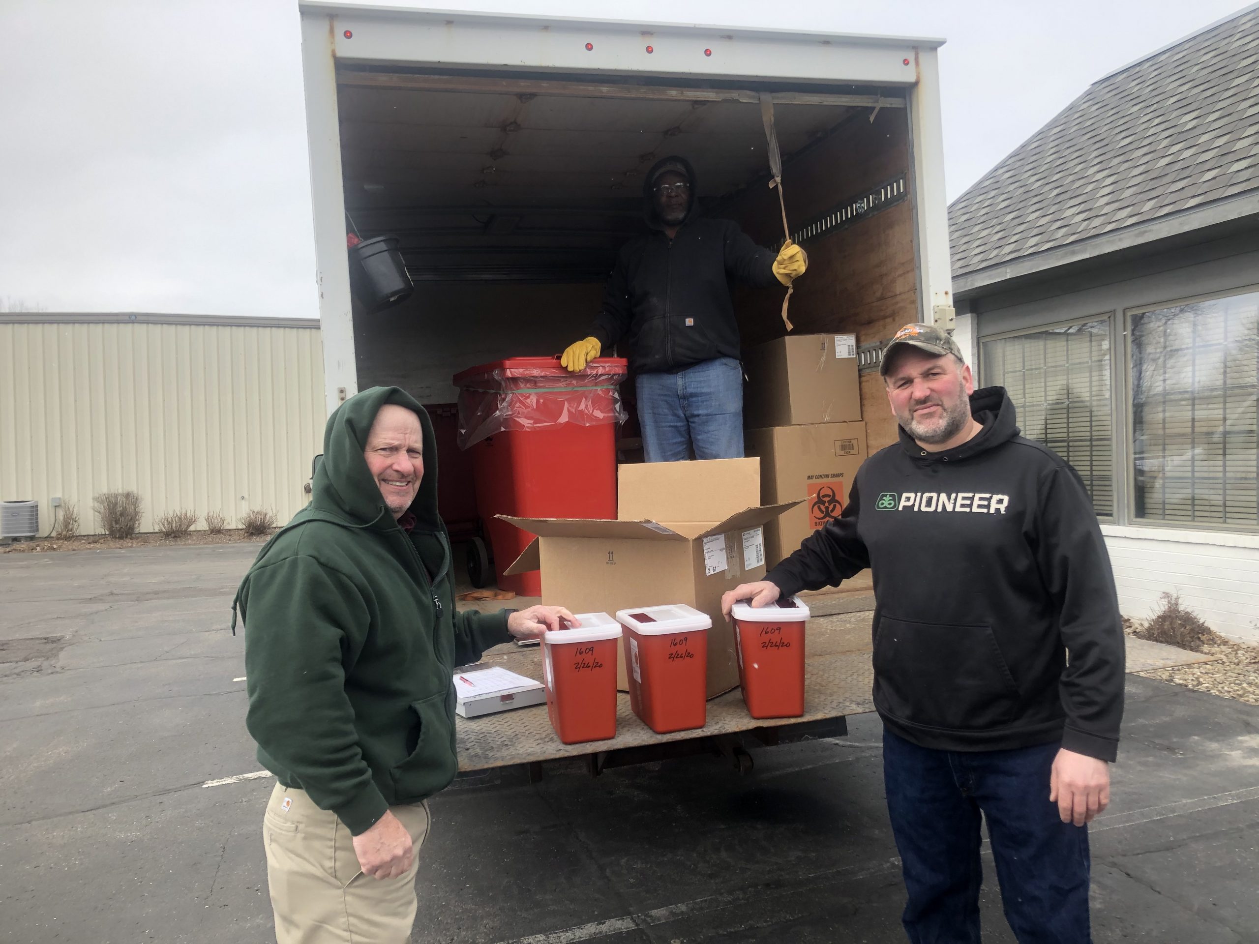 Top: MERI's Tyrone McGee is on hand as Grande's Randy Hardyman (left) hands producer Hardy Ripp a biohazard container as part of the sharps collection event held recently in Waunakee